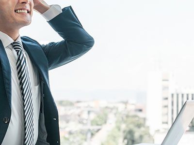 ノートPCを手に持つ女性のイメージ画像